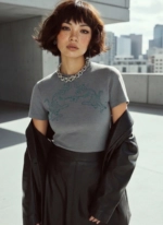 Model trägt graues T-Shirt mit Motiv und schwarzen Blazer in urbaner Outdoor-Szene
