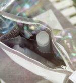 Blick von oben in weißes Beautycase mit dunkelgrauem, weiß gepunktetem Innenstoff und Seitenfächern