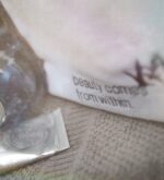Weiche Nahaufnahme des gestickten Schriftzugs auf weißem Beautycase