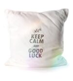 Weißes Kissen 48 x 48 cm mit aufgesticktem Schriftzug „Keep Calm and Good Luck“ auf hellem Hintergrund