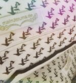 Nahaufnahme der Kissenrückseite mit Reißverschluss, Kranich-Rapportmuster und meindaruma-Label