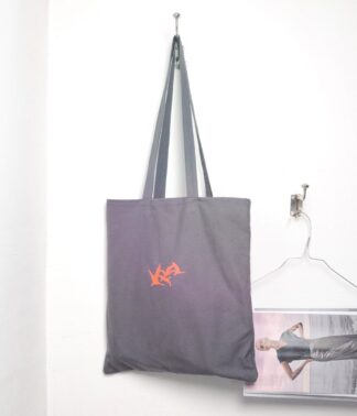 Dunkelgrauer Canvas-Beutel mit neonlachsfarbener Kranich-Stickerei an Wandhaken