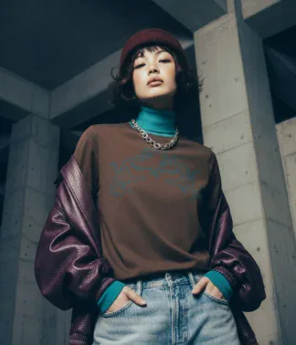 Model trägt braunes T-Shirt mit Tiger-Motiv vor urbaner Betonarchitektur