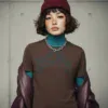 Model trägt braunes T-Shirt mit Tiger-Motiv vor heller Betonwand in urbaner Umgebung