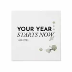 Freigestellte Grußkarte „YOUR YEAR STARTS NOW“ auf cremefarbenem Naturpapier mit dezenten Aquarellflecken